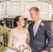 A couple on their wedding day standing in a white gazebo in the grounds of a hotel