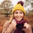 Girl in a bobble hat and scarf in autumnal parkland