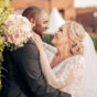 A couple on their wedding day smiling and embracing outdoors in the evening sun