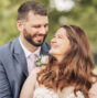 A couple on their wedding day smiling and laughing together outdoors
