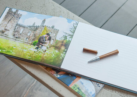Stock style image of a wedding guest signing book and pen