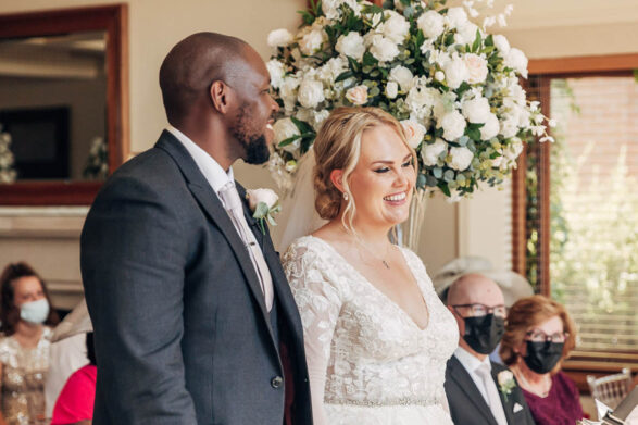 A couple smiling and holding hands during their wedding ceremony