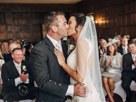 A bride and groom have their first kiss after their wedding ceremony