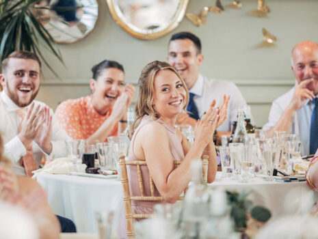 Wedding guests clapping during the speeches at a wedding reception