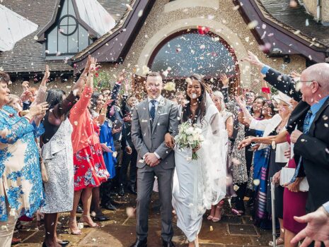 A bride and groom being showered with confetti outside a church