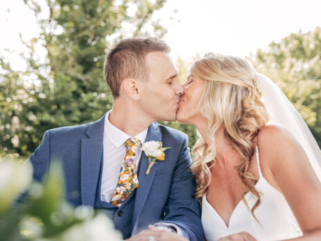 A wedding couple kissing outdoors after signing the marriage register