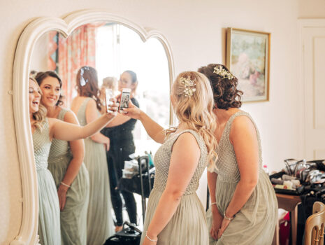 Two bridesmaids taking a selfie together in a mirror