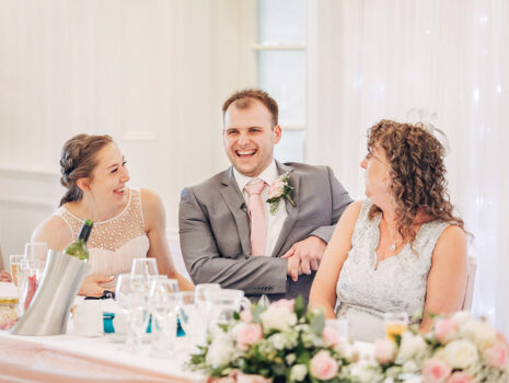 Wedding guests sharing a joke and laughing at the reception